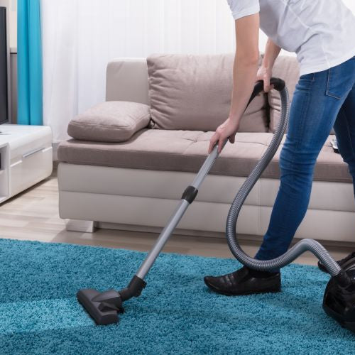 Young man using a corded vacuum